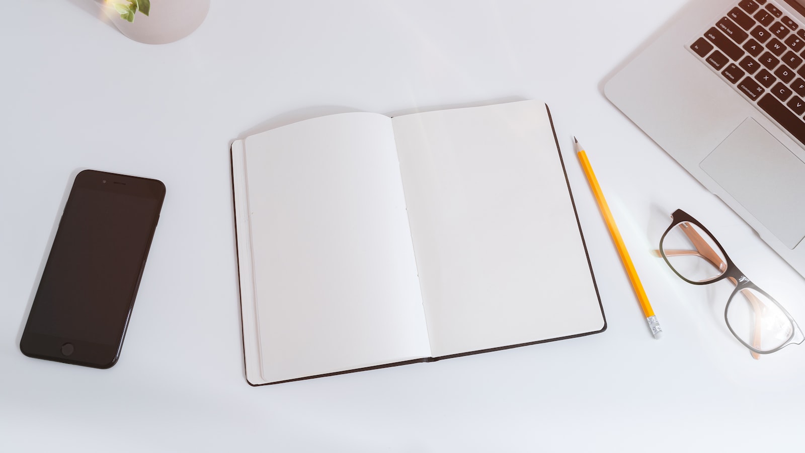 A freelancer sitting at a desk reviewing notes during a video call with a client.