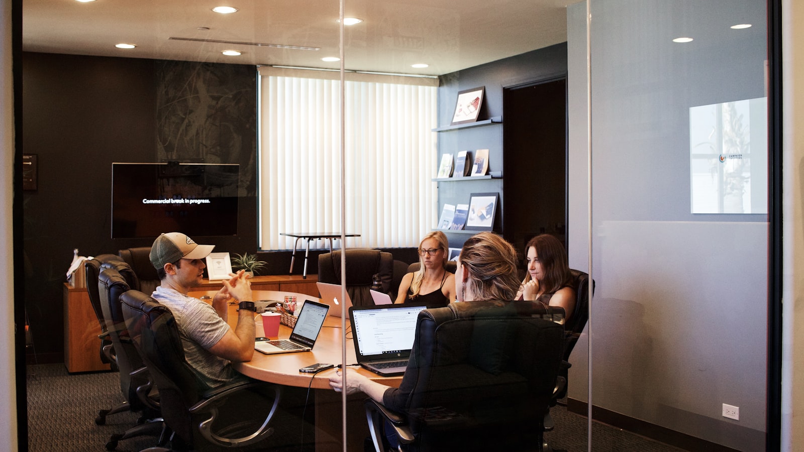 Two people shaking hands across a desk after a friendly business meeting.