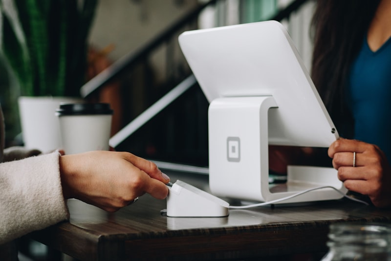 A laptop and coffee cup on a desk near a sunlit window